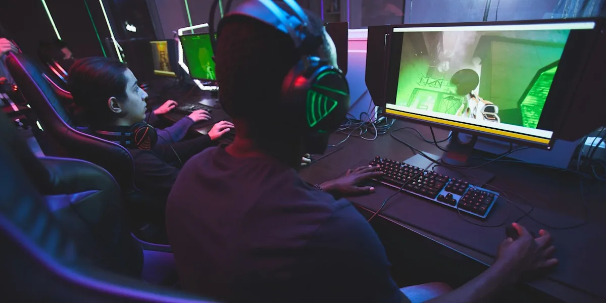 10 videospillsjangre Tre gamere med hodetelefoner foran hver sin PC