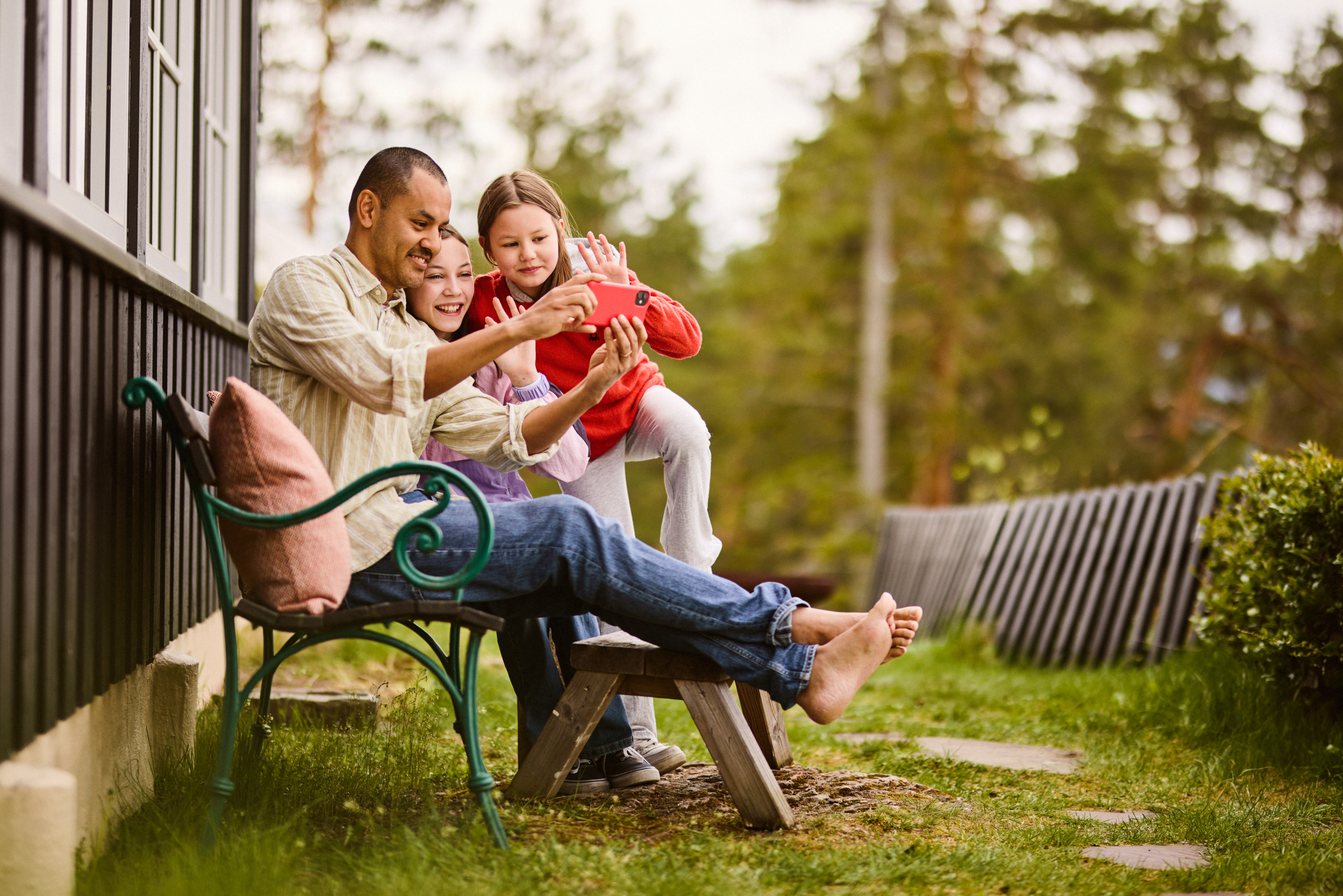 Familie på hyttetur ser på mobilen Foto: Andreas Kleiberg, Altibox