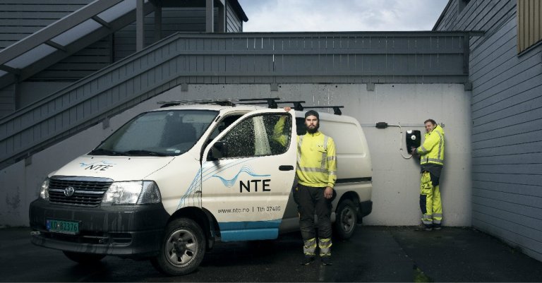 To elektrikkere fra NTE står forran en zaptec lader