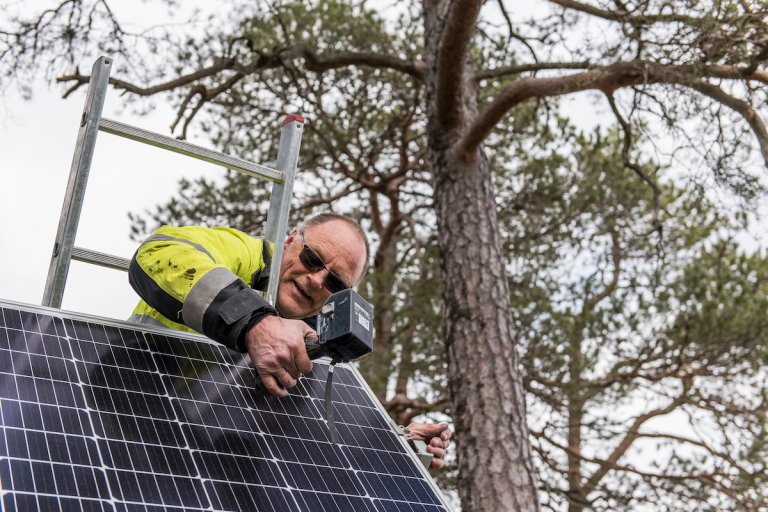 Elektriker monterer solcellepanel i skogen