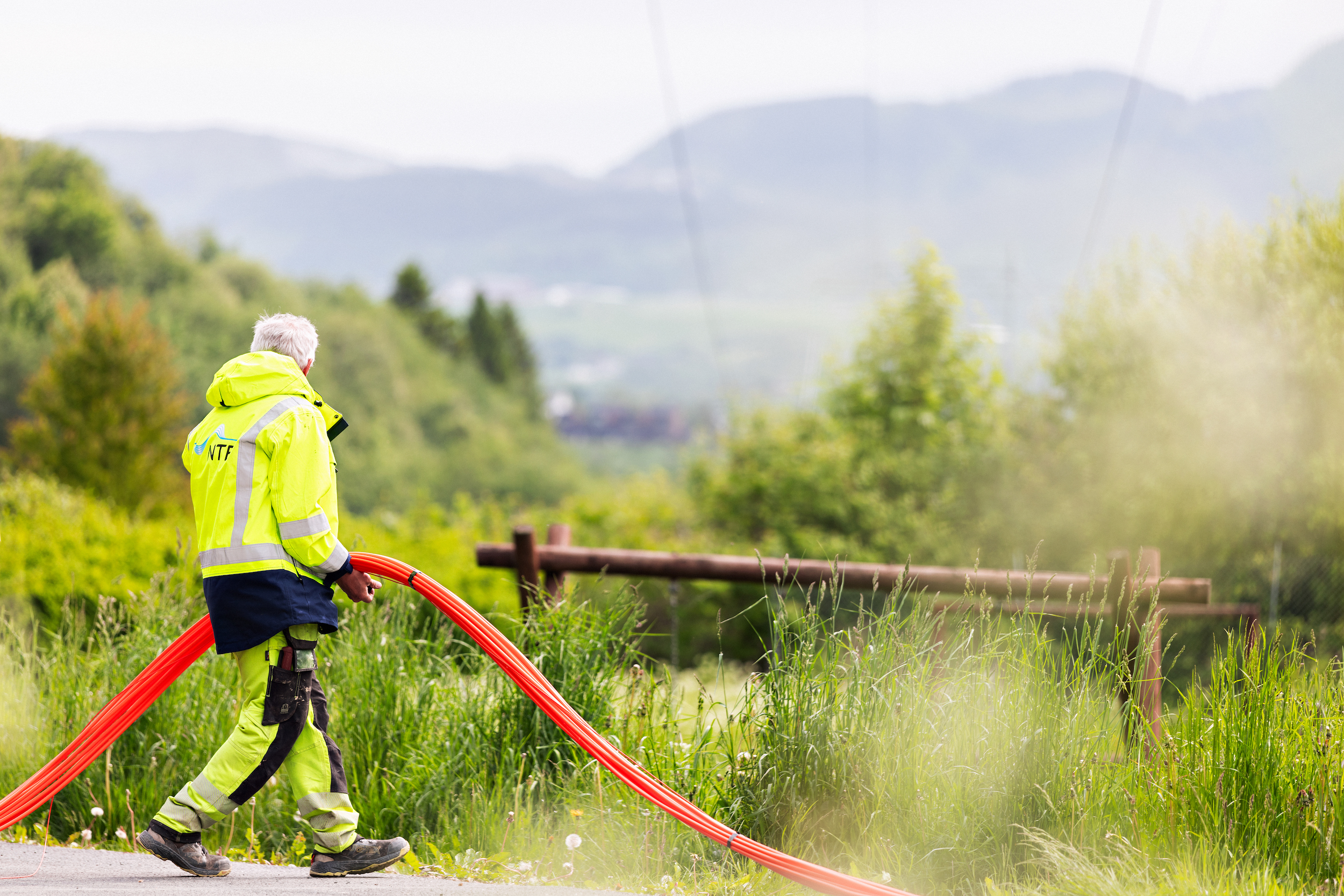 Mann holder en fiberkabel i hånden