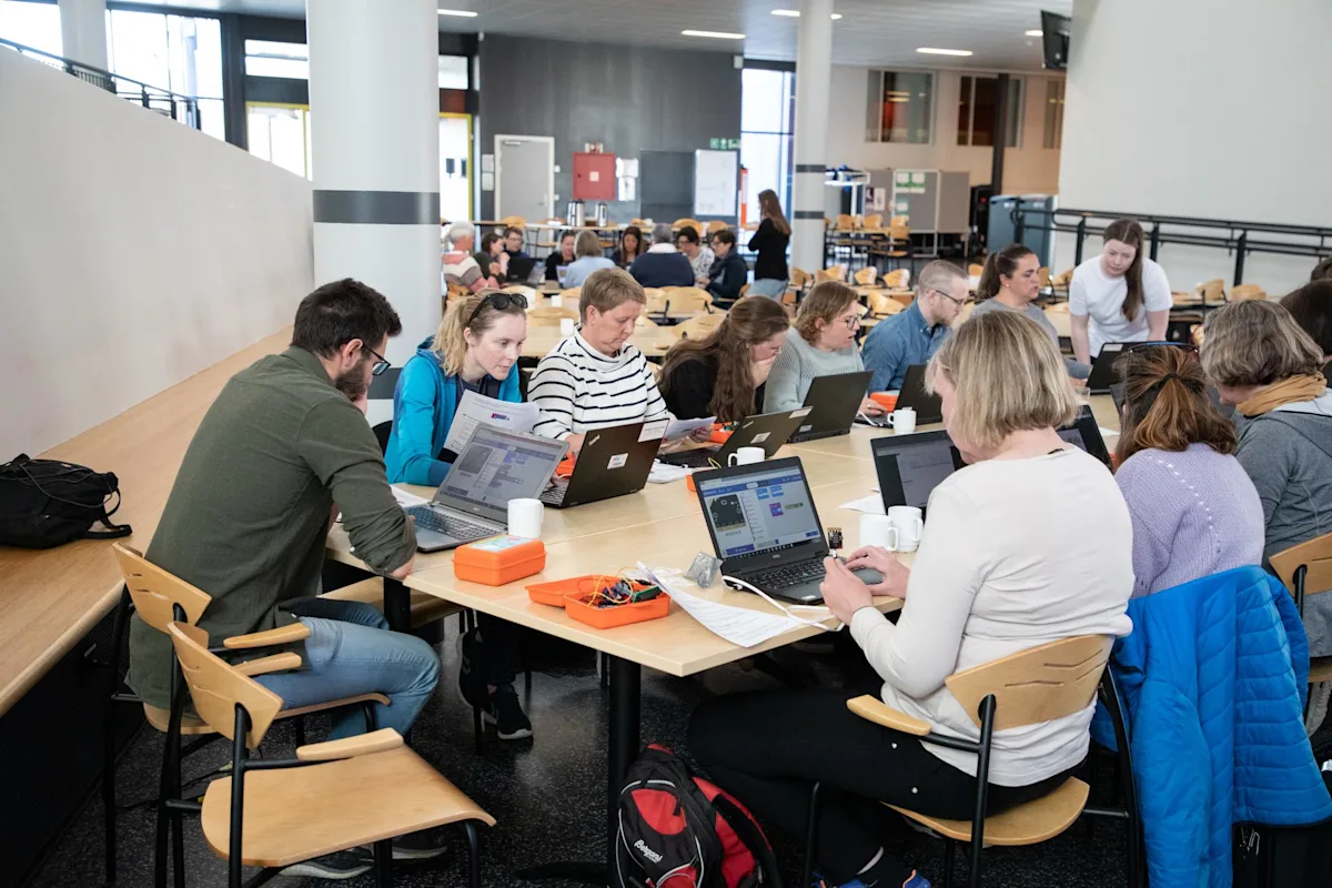 Lærer ved en skole sitter i lag å lære om koding for kids Lærer ved en skole sitter i lag å lære om koding for kids