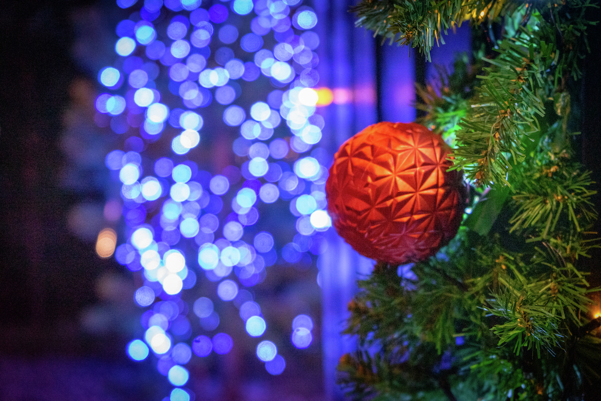 Julekule på juletre med lys i bakgrunn