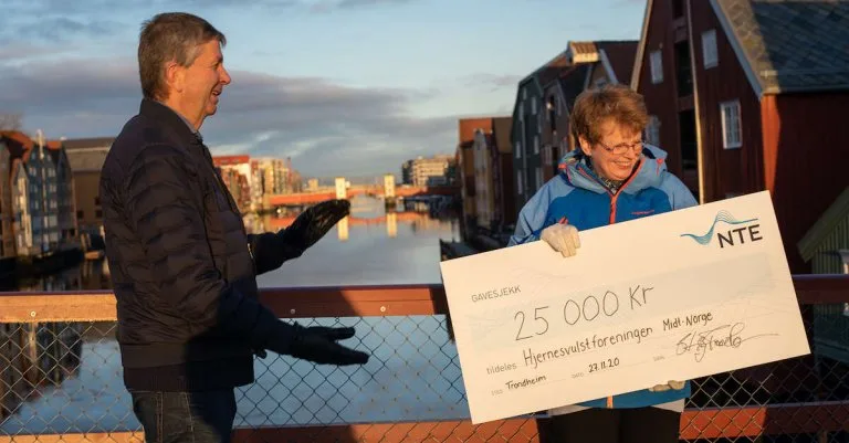 Hjernesvulstforeningen gavesjekk Dame overleverer gavesjekk til hjernesvulstforeningen