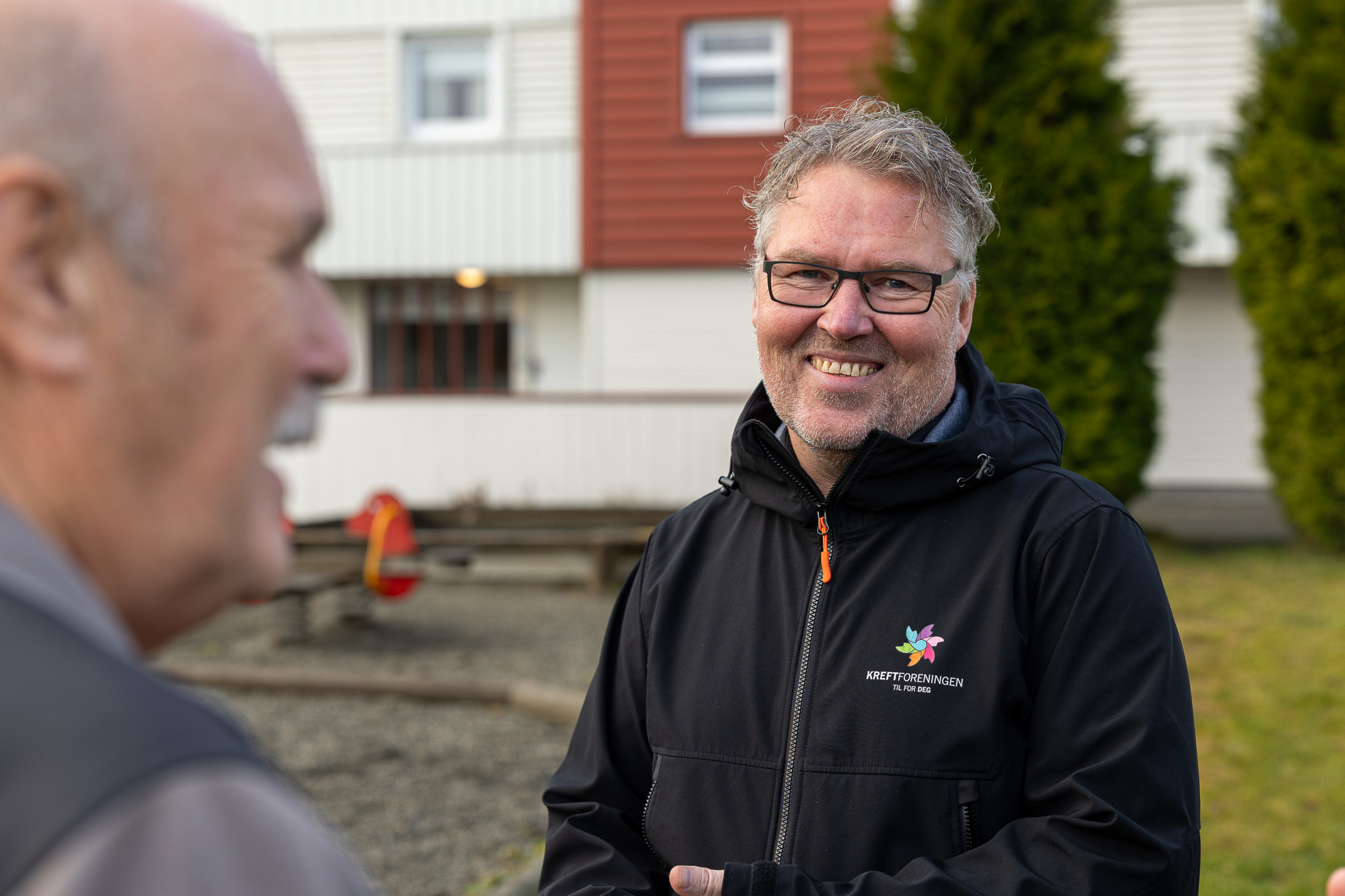 Smilende mann. På jakken har han logoen til Kreftforeningen. 