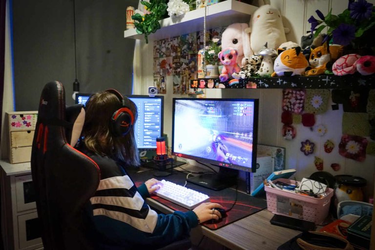 Jente spiller på en datamaskin med to skjermer
