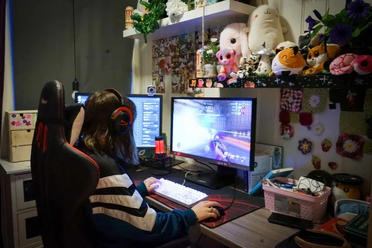 Sol Angelica Jente spiller på en datamaskin med to skjermer
