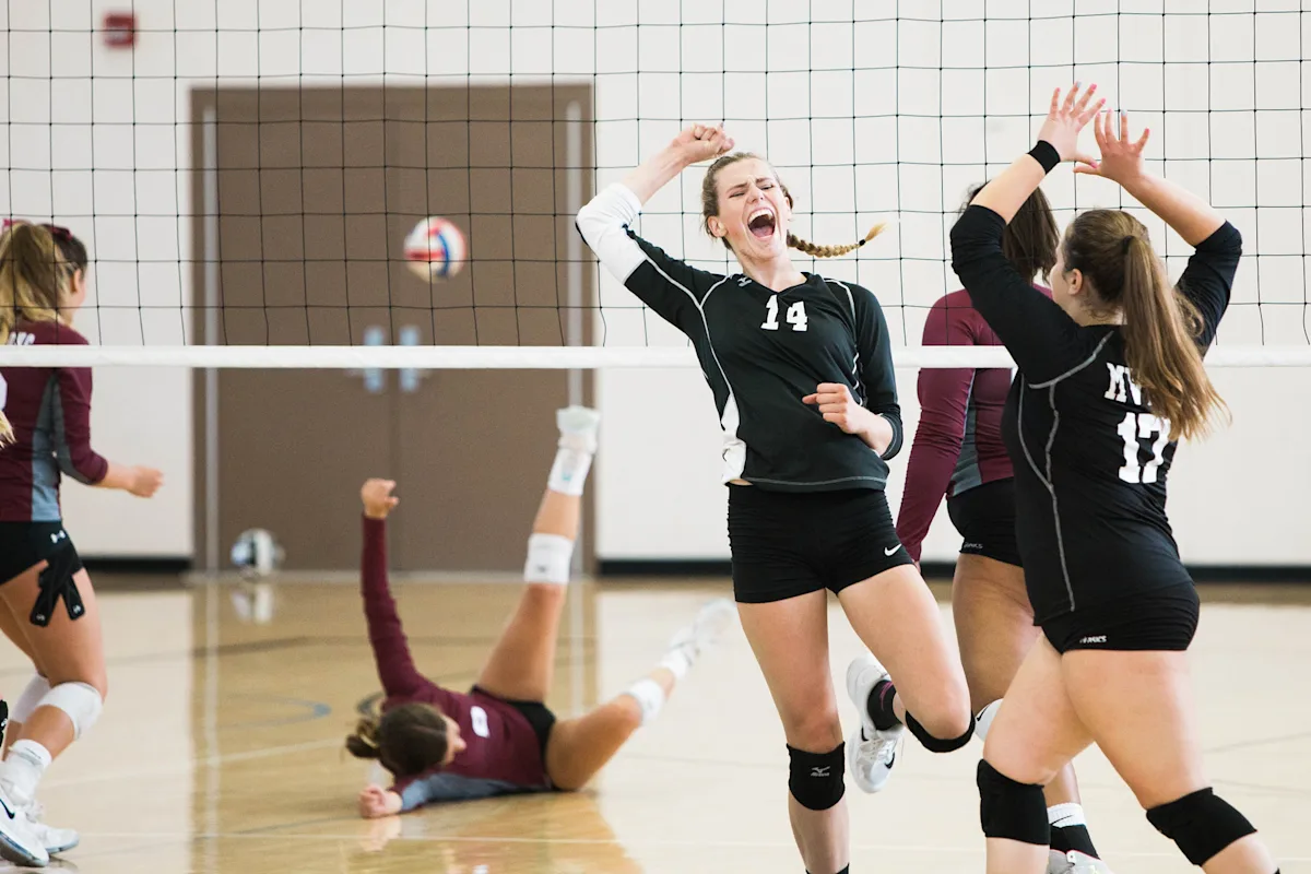 Sponsorvirksomhet Kvinnelige volleyball-spillere jubler på banen