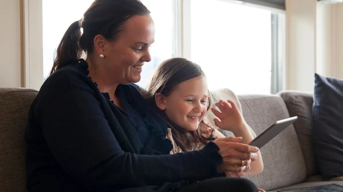 morogdatterpånett Mor og datter som ser på en iPad sammen