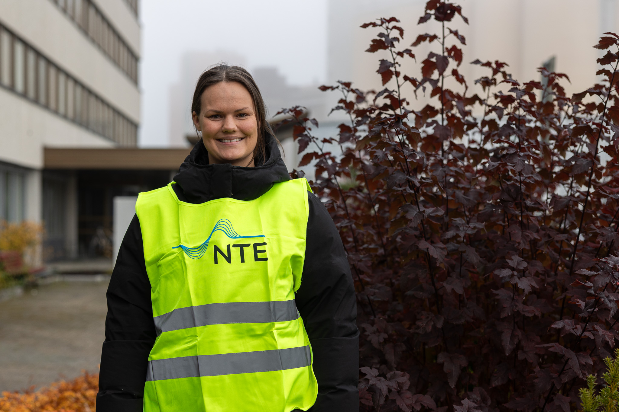 Smilende kvinne med refleksvest