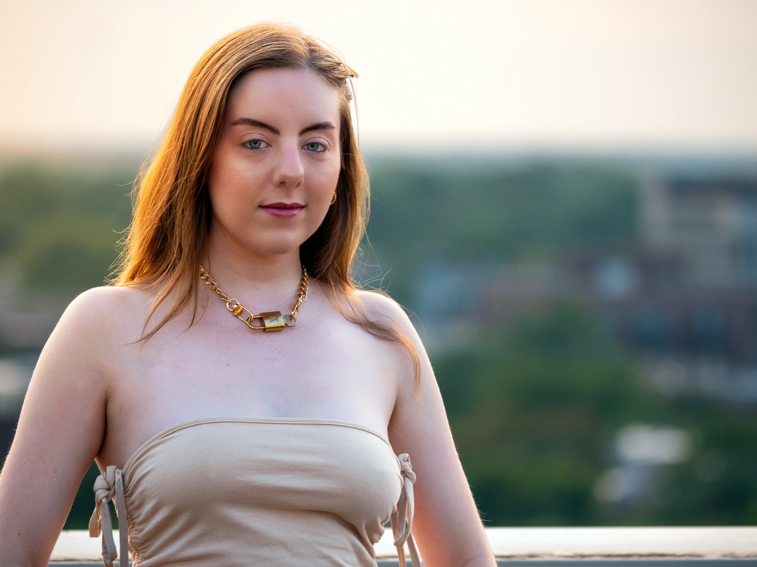 Beige strapless top with gold chain, rooftop portrait in warm natural backlight