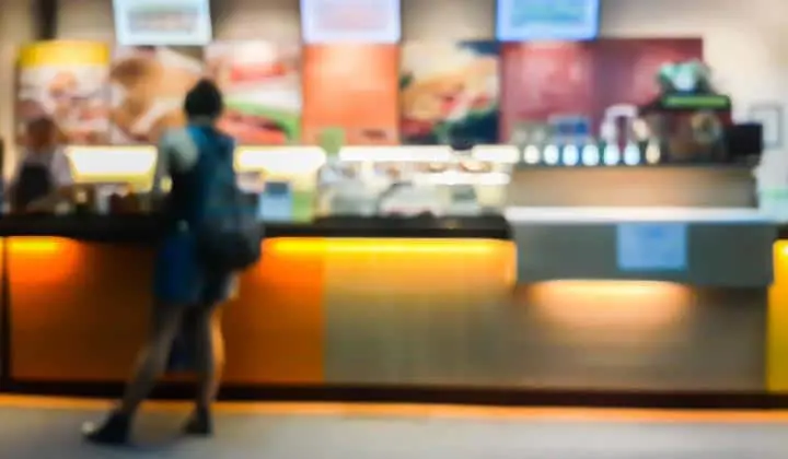 Image of a person next to a food checkout counter relating to the case of McDonald's