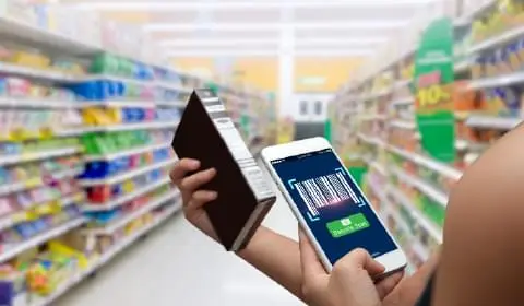 Image of a lady scanning the barcode of a product on her smartphone in a departmental store to portray the retail industry