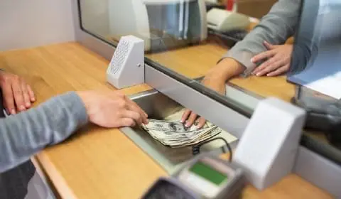 Image of a cashier passing money to a customer in a bank to portray the banking industry