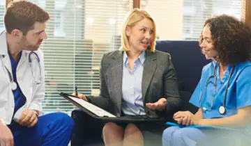 Image of a senior executive and nurse leaders in a dicussion within a hospital setting, relating to text that follows