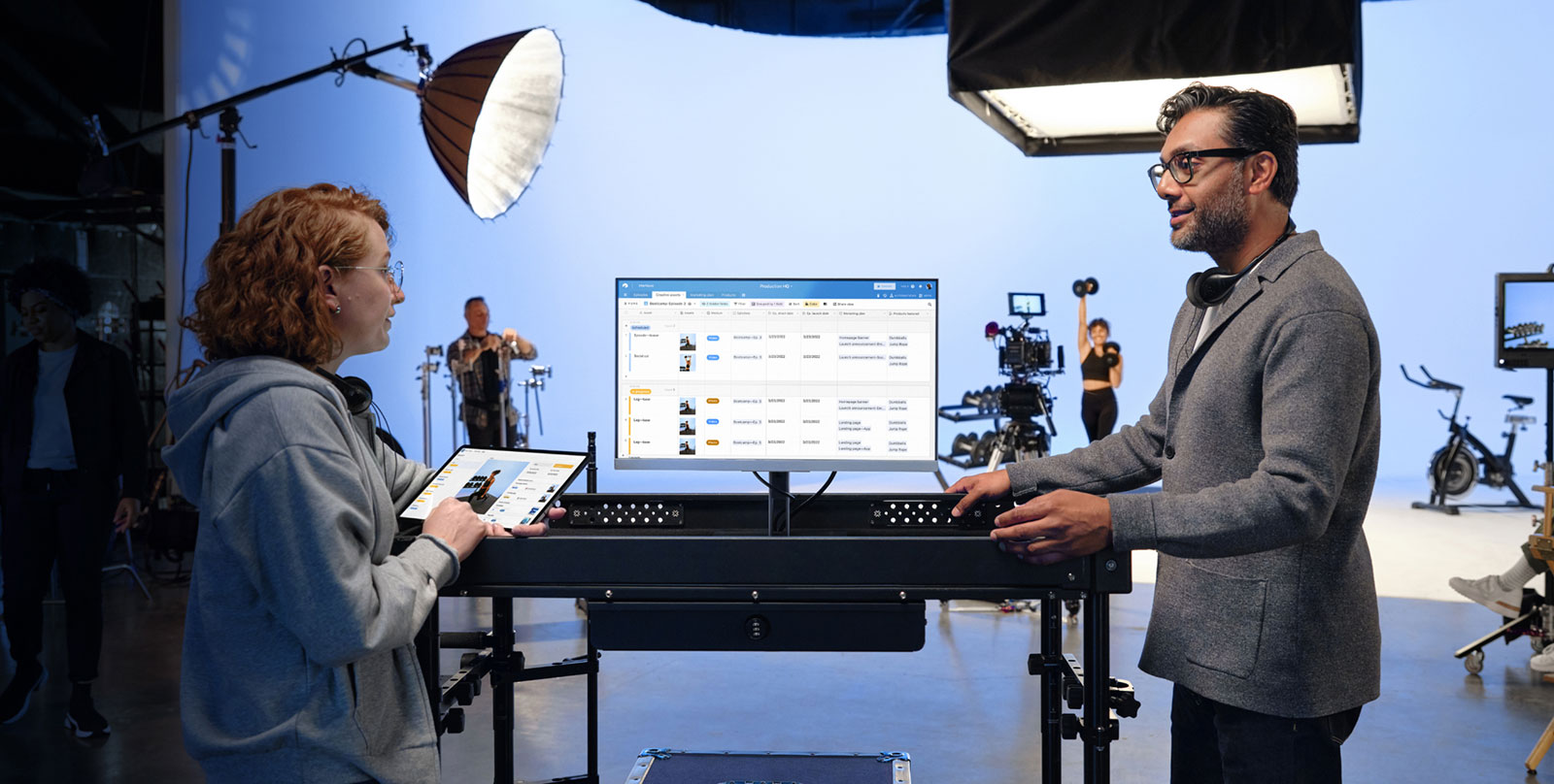 Several people are in a conference room. A laptop shows an Airtable calendar view