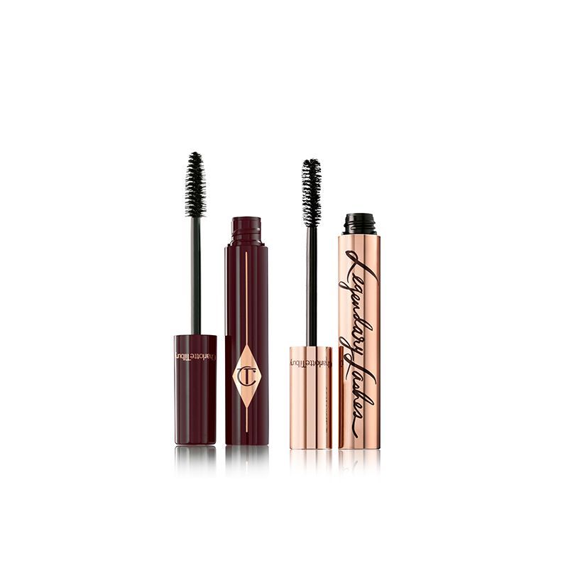 two, open black mascaras, one in golden packaging and the other in dark crimson, with their applicators next to them. 