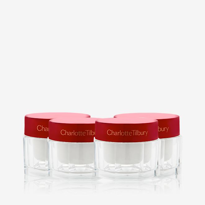 Limited Edition Year of Magic Skin still life A collection of pearly-white face creams in glass jars with eye-catching, red-coloured lids.
