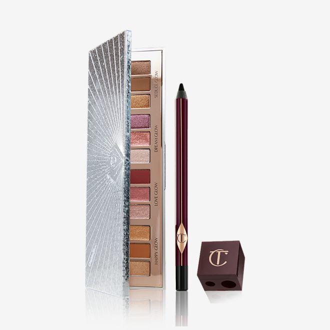 Bejewelled Smokey Eye Kit open An open eyeshadow palette with twelve eyeshadows in matte and shimmery shades in pink, purple, red, gold, brown, and cream, an eyeliner pencil in black, and a lip and eye pencil sharpener.