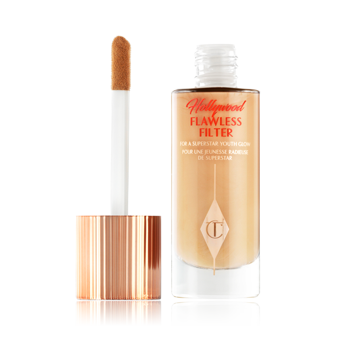 An open glow-boosting primer in a glass bottle with a rose gold-coloured lid with a doe-foot applicator.