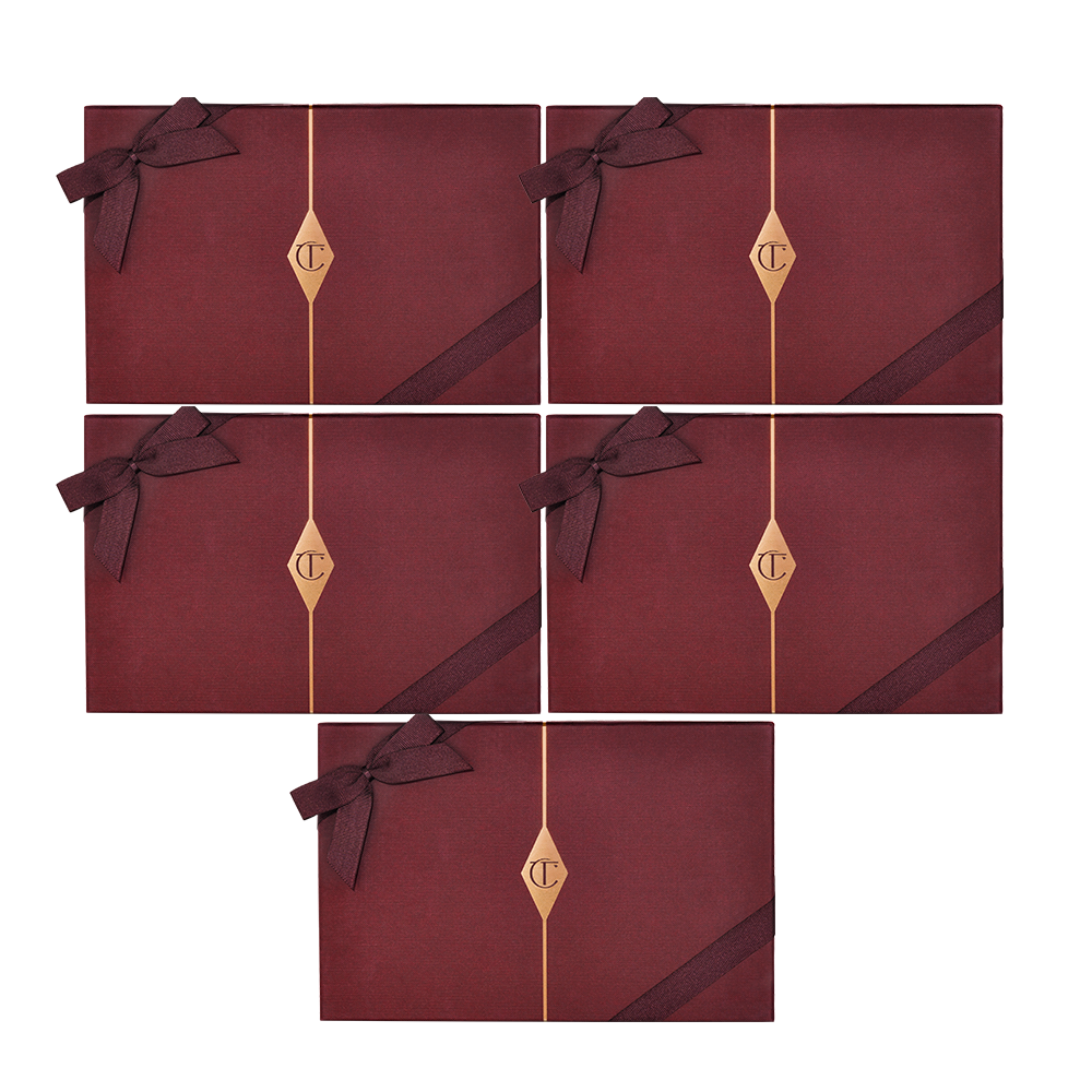Five, dark crimson-coloured gift boxes with matching bows on them and the CT logo printed in the middle in gold.