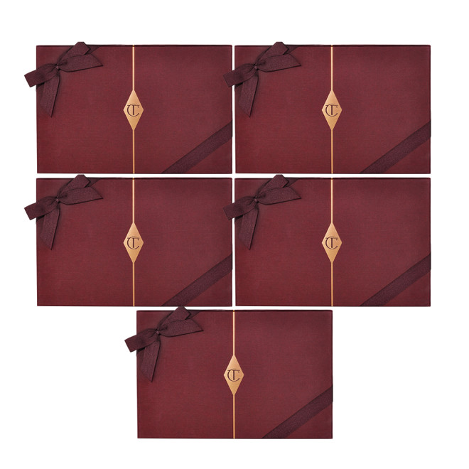 Five, dark crimson-coloured gift boxes with matching bows on them and the CT logo printed in the middle in gold.