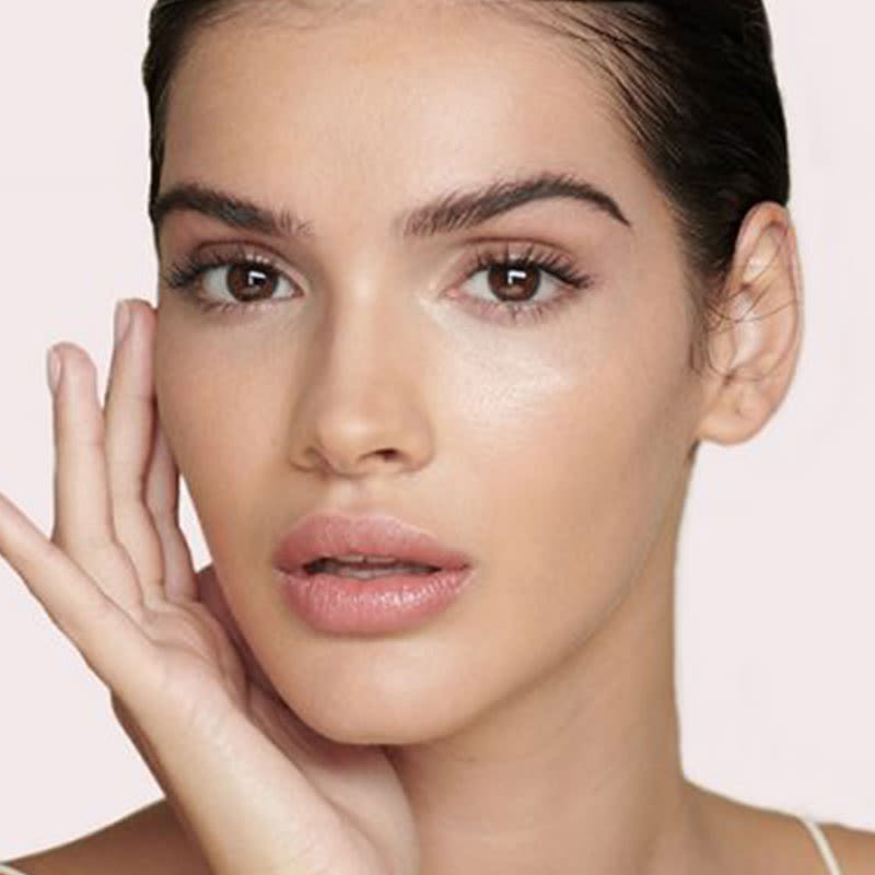 A light-tone brunette model with glowy, glass skin that looks fresh without makeup. 