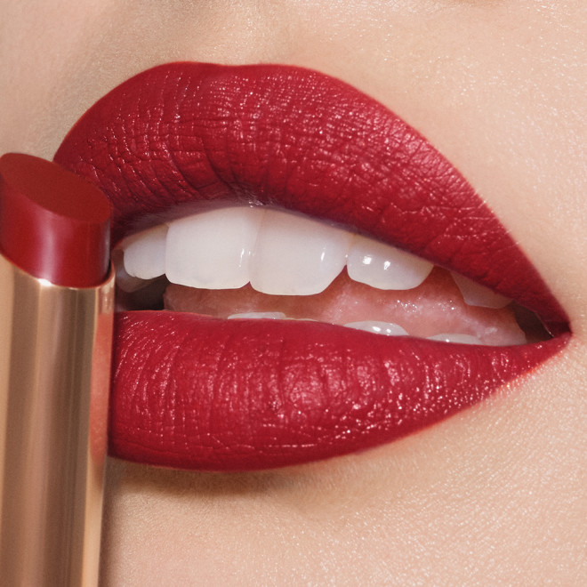 Lips close-up of a fair-tone model wearing cherry ruby red lipstick with a matte finish.