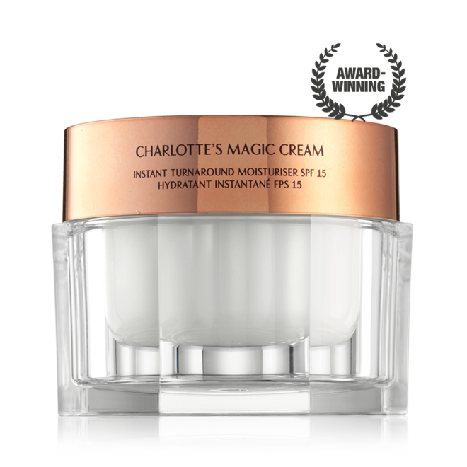 Pearly-white face cream in a glass jar with a gold-coloured lid with text on it, 'Charlotte's magic cream'.