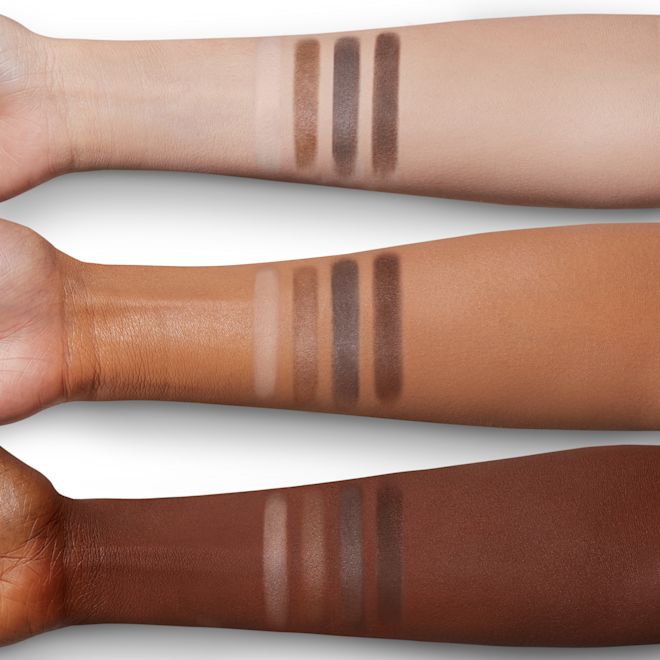 Luxury Palette in The Sophisticate arm swatches Arm swatches of four matte eyeshadows in cream, tan, taupe, and chocolate colours on fair, tan, and deep skin.