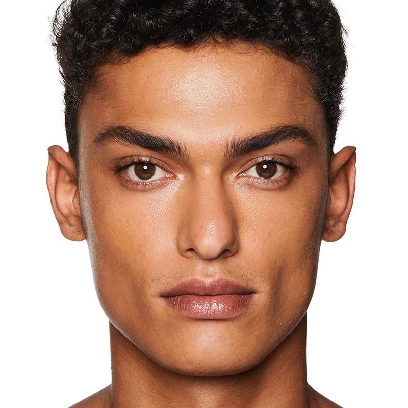 A medium-tone brunette male model with brown eyes wearing a no-makeup makeup look. 