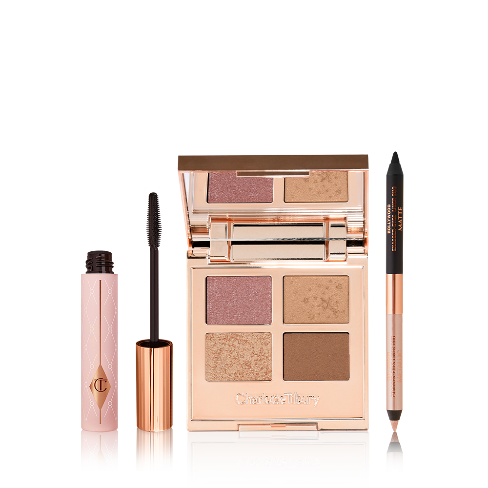 Black mascara in a sheer pink tube with a gold coloured lid and fluffy applicator, open, mirrored-lid quad eyeshadow palette with soft earthy-tones in shades of pink, brown, and gold, and a double-ended eyeliner pen in black and nude beige.