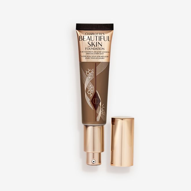 Beautiful Skin Foundation in Shade 15N open An open foundation wand in gold packaging with a pump dispenser and a dark-brown-coloured body to show the shade of the foundation inside.