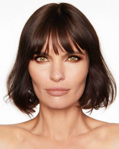 A medium-light-tone brunette model with hazel eyes wearing shimmery, copper and gold eyeshadow with rust and copper-coloured eyeliner on the upper lid and lower waterline. 