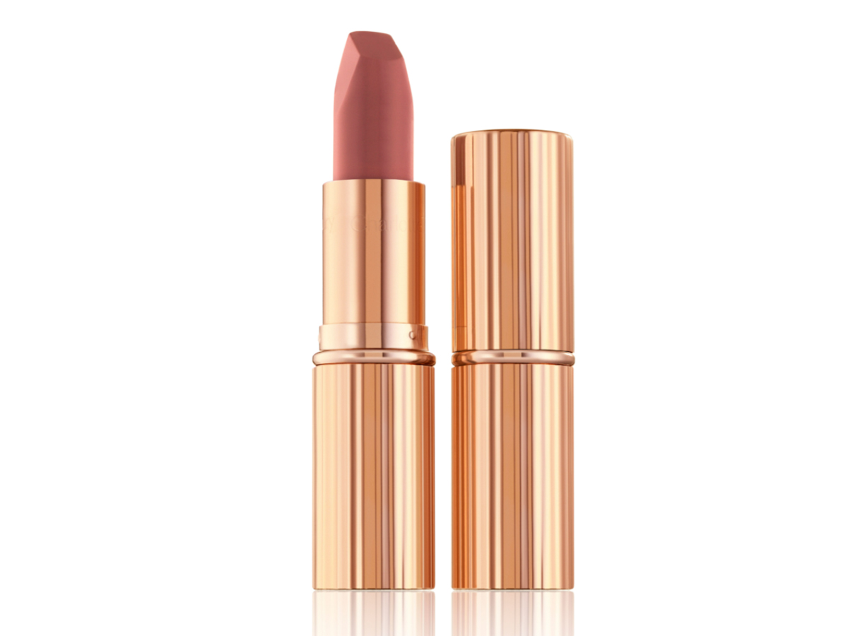 Two lipsticks, with and without lid, in a mid-toned muted nude-rose matte shade, in sleek, gold-coloured tubes. 