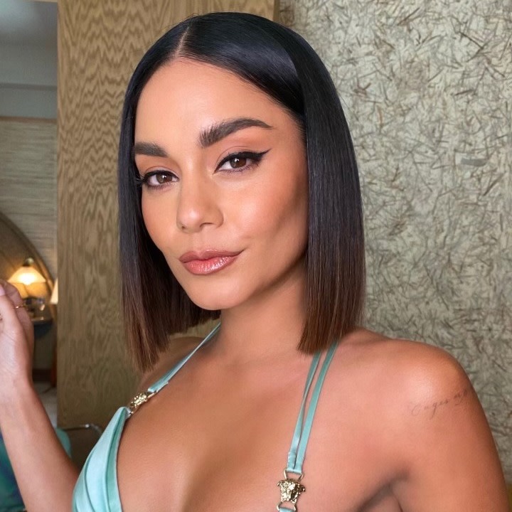 Vanessa Hudgens at The SAG Awards 2022 wearing smokey brown eye makeup with black eyeliner, dewy face base, peach blush, and nude pink lipstick with an ombre blue dress with thin straps.