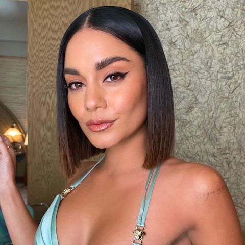 Vanessa Hudgens at The SAG Awards 2022 wearing smokey brown eye makeup with black eyeliner, dewy face base, peach blush, and nude pink lipstick with an ombre blue dress with thin straps.