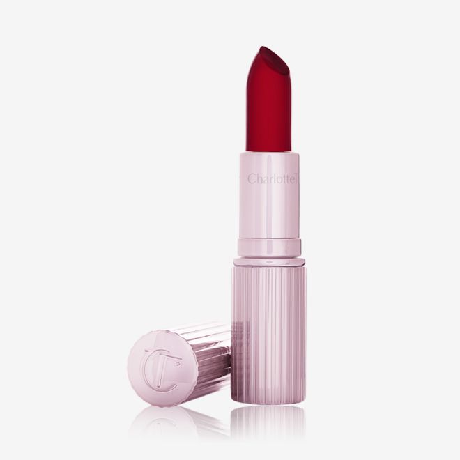 glowgasm Lips in Jewelgasm open An open glowy, colour-changing lipstick in a sheer red colour with a luminous purple-coloured tube and lid.