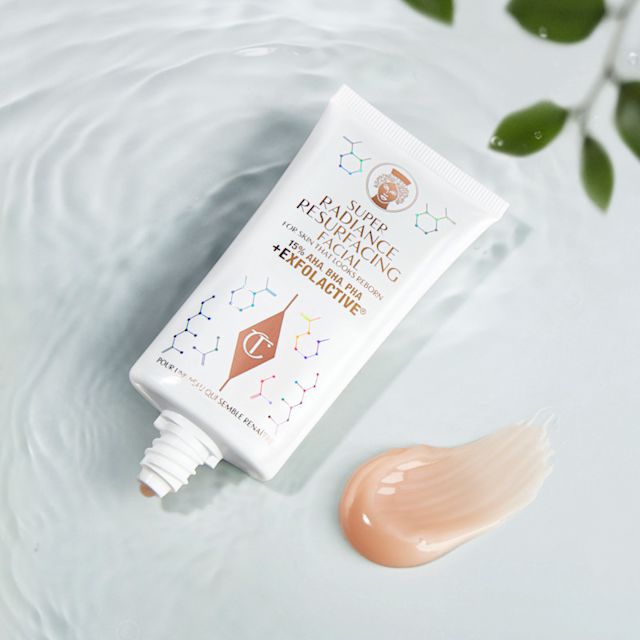 Un masque exfoliant chimique à rincer, présenté dans un tube blanc avec une inscription dorée, accompagné d’un swatch crémeux couleur brun champagne.