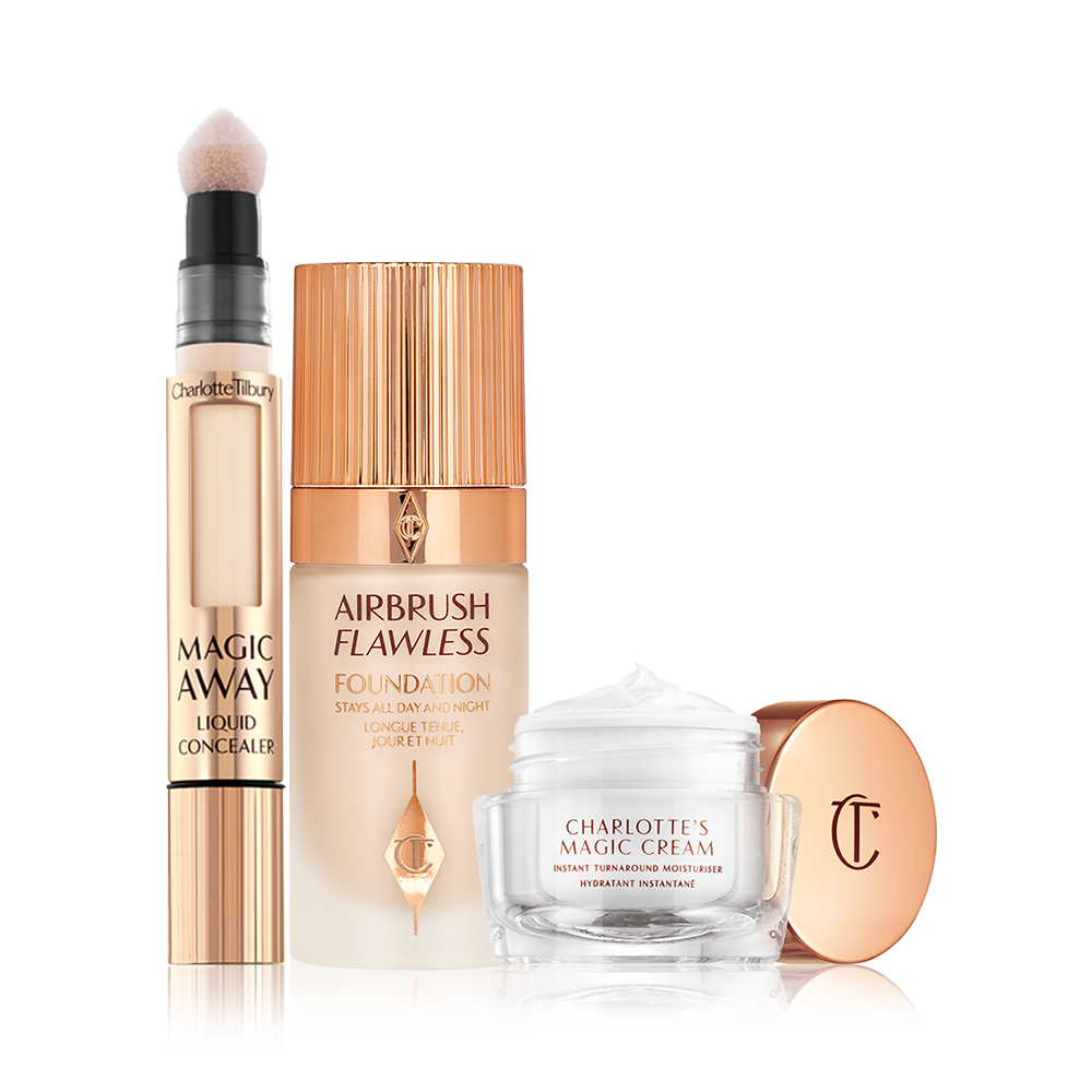 Creamy liquid concealer in a gold-coloured tube with a soft sponge applicator end, foundation in a frosted glass bottle with a gold-coloured lid, and pearly-white face cream in a glass jar with a gold coloured lid.
