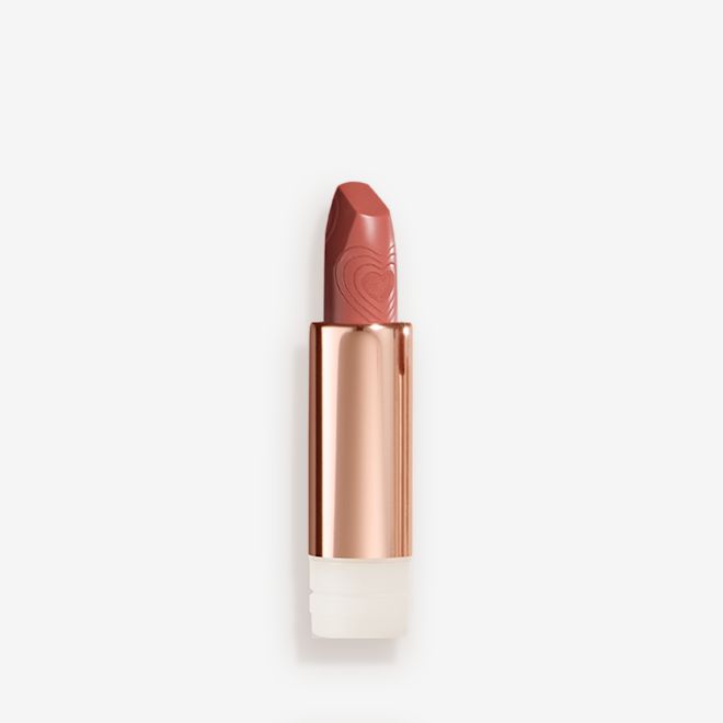 K.I.S.S.I.N.G Lipstick In Nude Romance refill A lipstick refill with its lid removed in a nude peach shade in a gold-coloured tube.