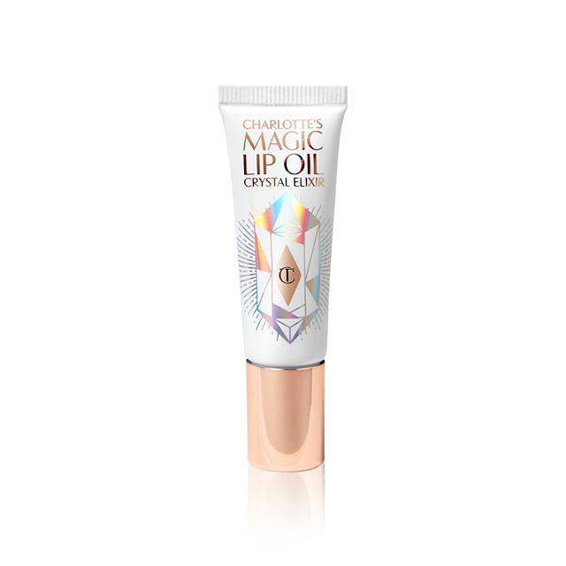 A lip oil in a white coloured tube with reflective geometric patterns on it in silver colour and a rose-gold-coloured lid. 