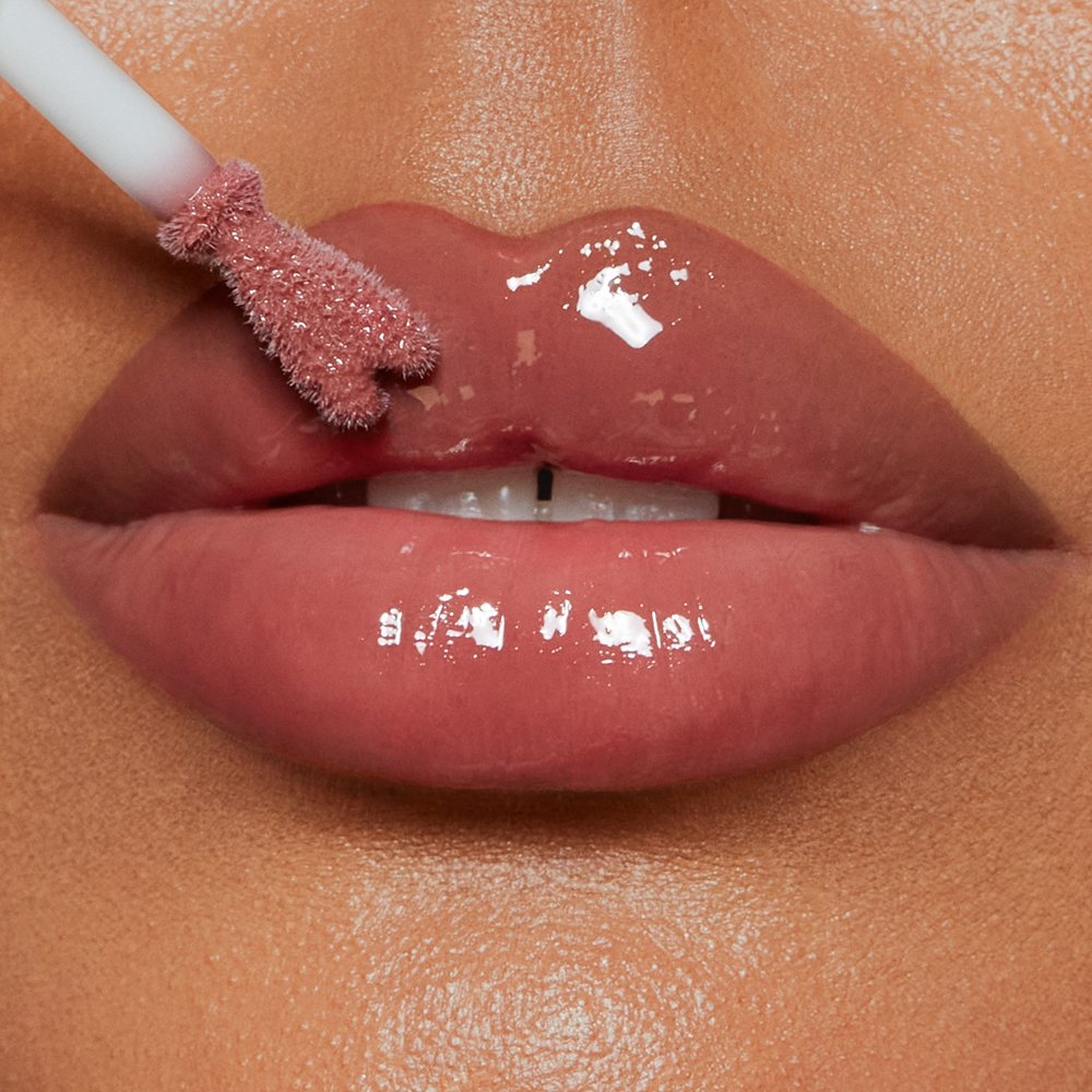 Model wearing Pillow Talk Medium Collagen Lip Bath berry-pink lip gloss