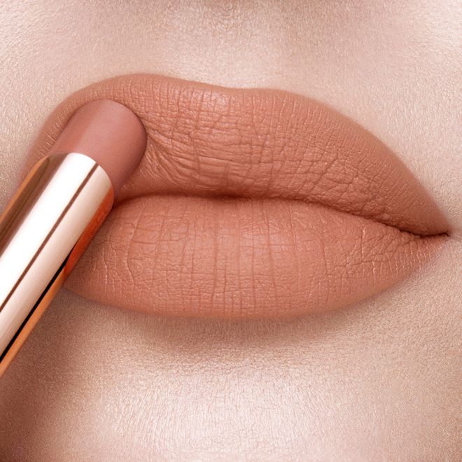 Limitless Lucky Lips in Velvet Nude on fair-tone lips close-up Lips close-up of a fair-tone model applying a soft taupe lipstick with a matte finish.