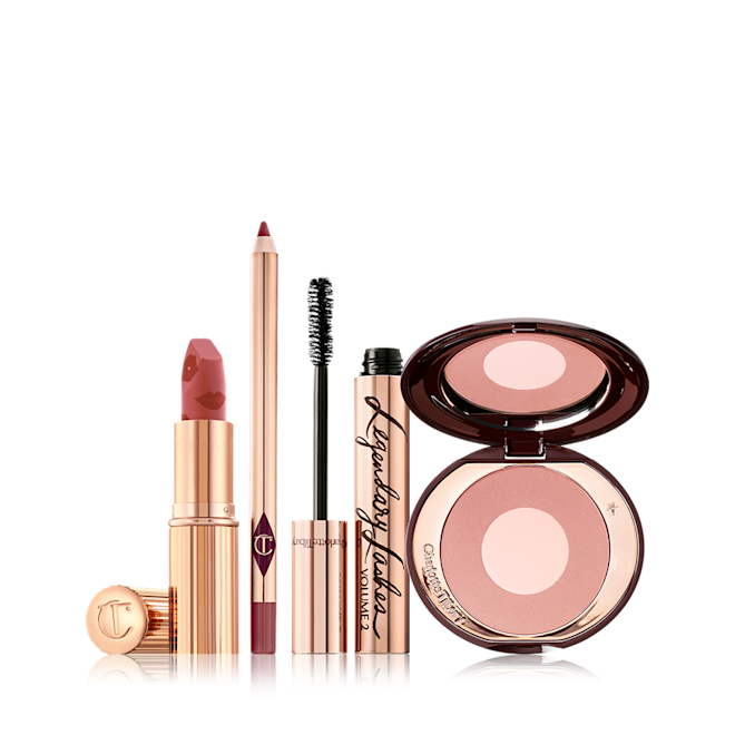 Mrs Kisses Bundle open An open matte lipstick in warm pink with a warm-pink lip liner pencil, black mascara in gold packaging, and two-tone blush in a nude pink shade.