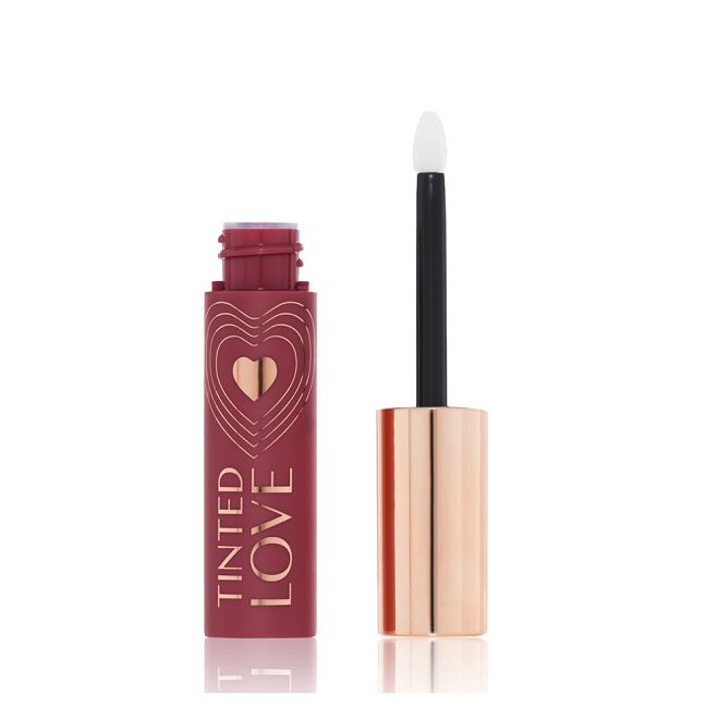 An open lip and cheek tint with a gold-coloured lid in a dark cherry-red-coloured tube.