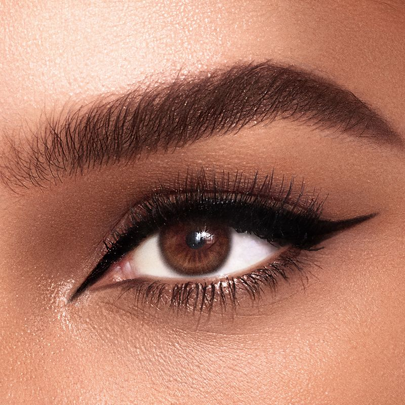 Single-eye close-up of a model with brown eyes wearing jet-black eyeliner in a cat-wing style.