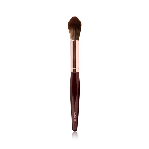 A powder brush with soft bristles and the handle in a dark crimson and rose-gold colour scheme. 
