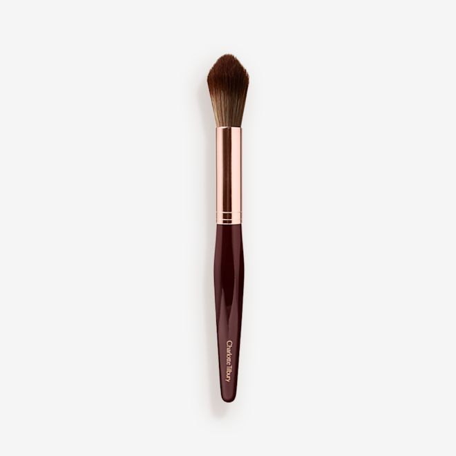 Synthetic Powder and Sculpt Brush A powder brush with soft bristles and the handle in a dark crimson and rose-gold colour scheme.