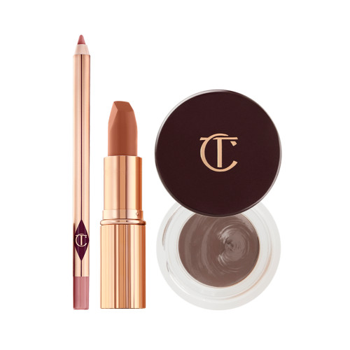 An open lip liner pencil in nude pink, open matte lipstick in nude pink in a gold-coloured tube, and an open pot of cream eyeshadow in a smokey taupe shade with its lid next to it.